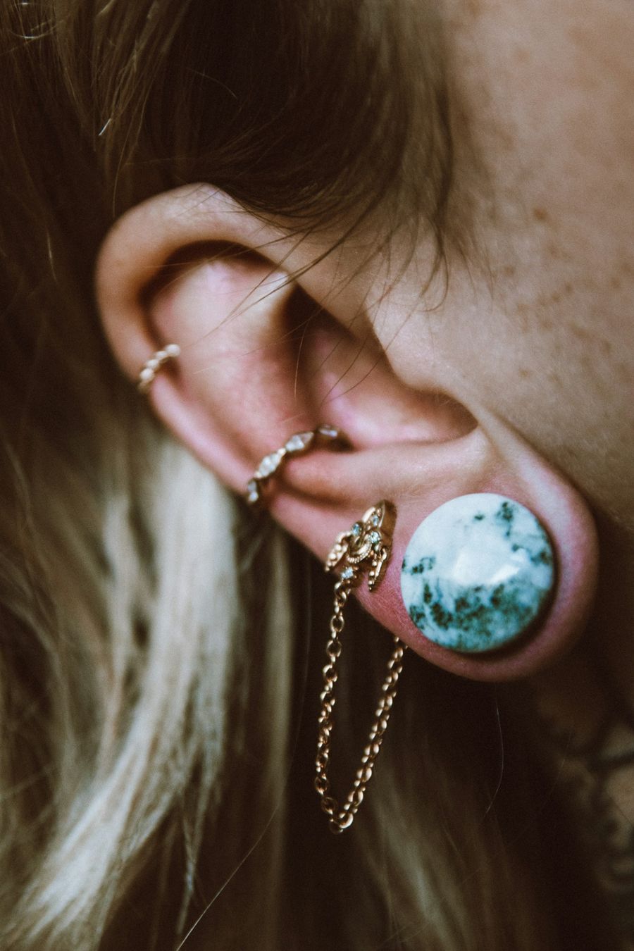 Close-up of an ear with several cartilage and lobe piercings