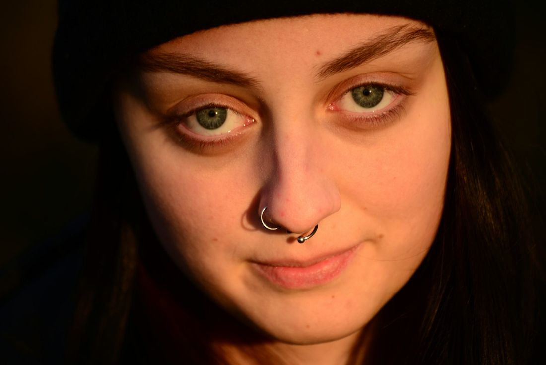 Portrait of a woman with a septum ring and nostril piercing